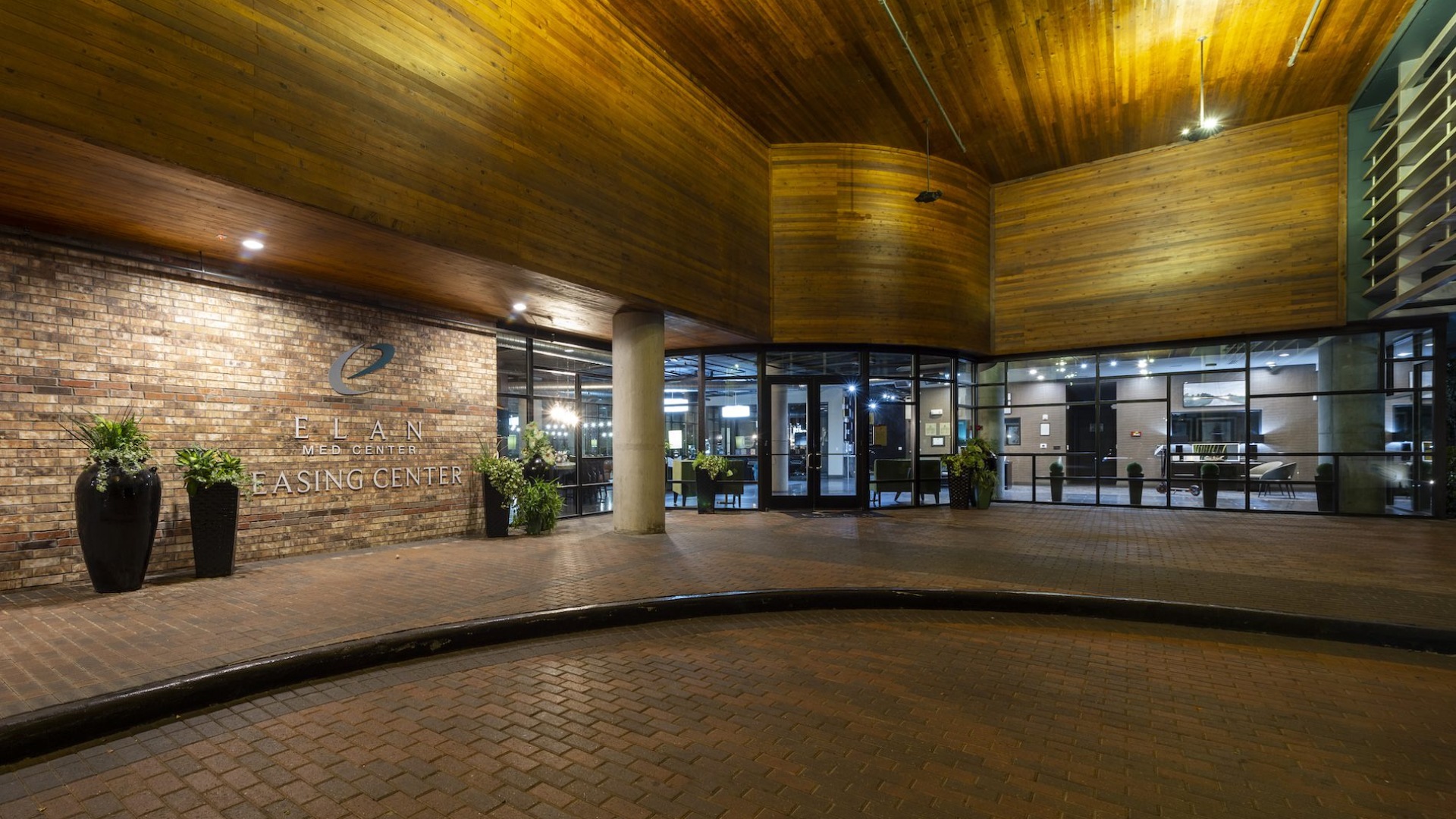 large driveway in front of a building with a sign on it