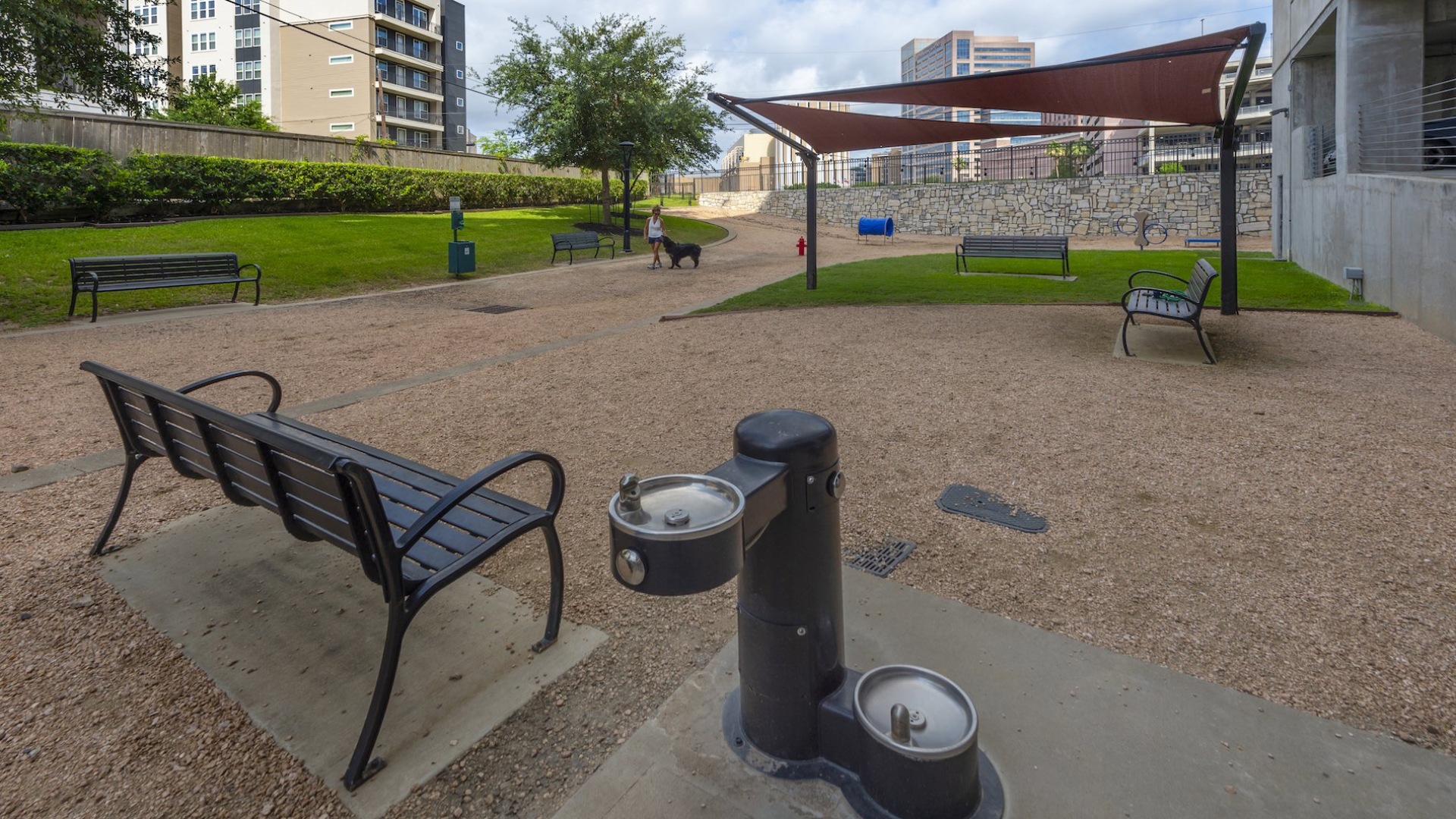 a dog park with bench and water fountain