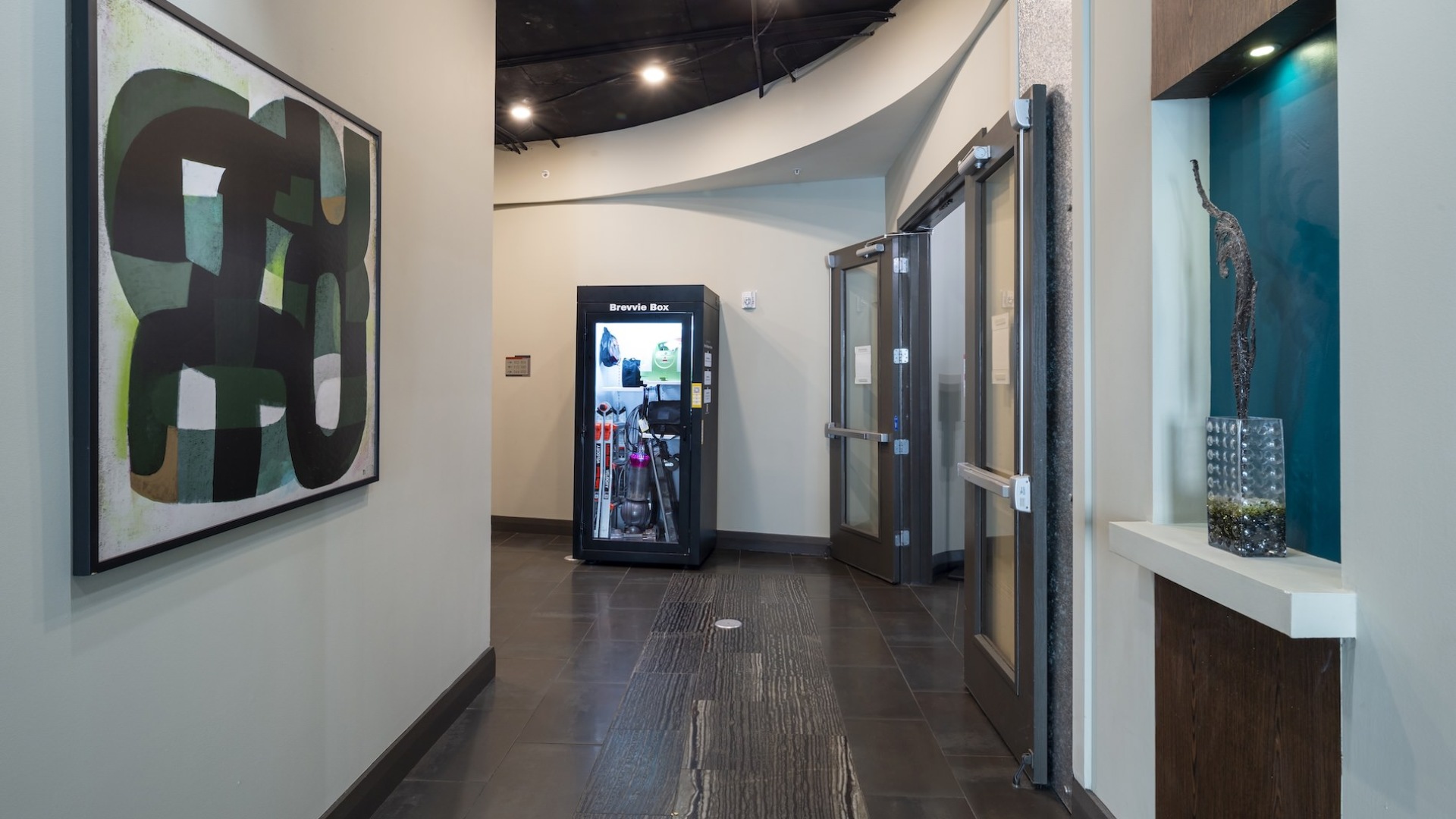 hallway with art on the wall and wood flooring