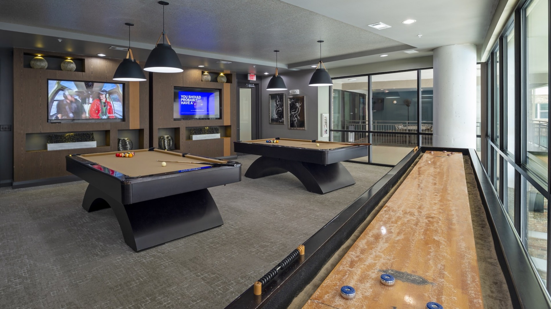 game room with shuffle board pool tables with tvs