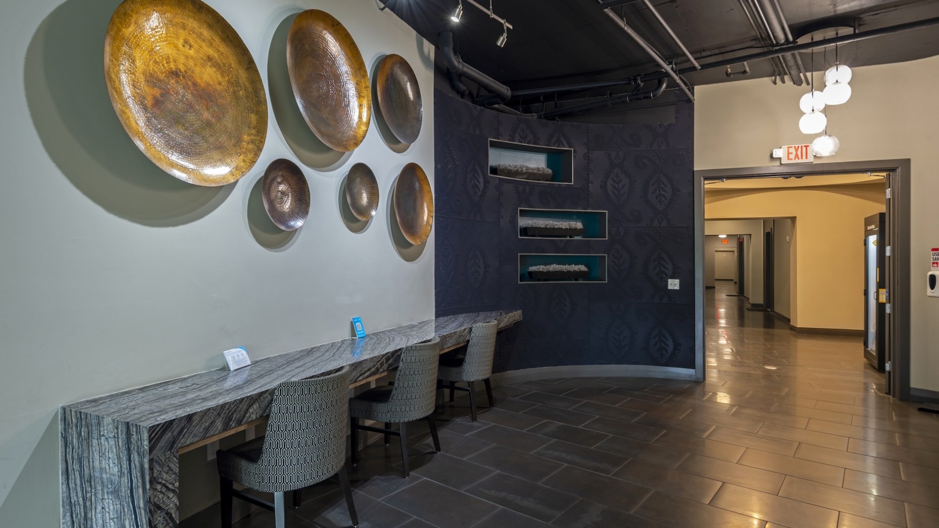table and seating along a wall with large pieces of art on the wall